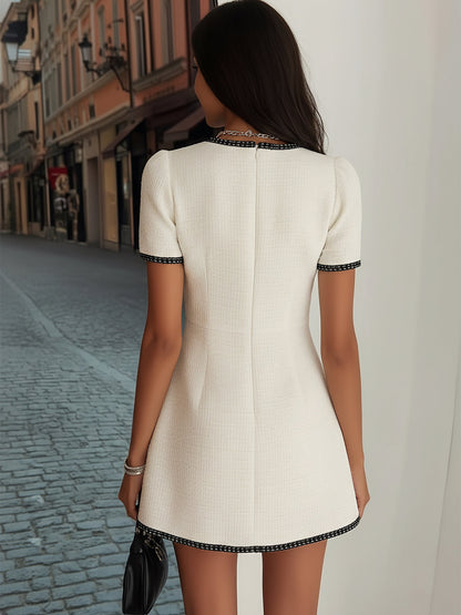 Elegante vestido de tweed color crema con ribete negro